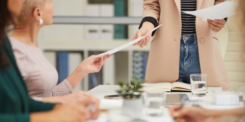 unrecognizable-woman-with-hand-outs-at-meeting-5HMGW6M.jpg